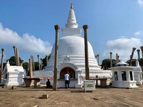 The white Thuparamaya stupa with ancient stone pillars at Anuradhapura