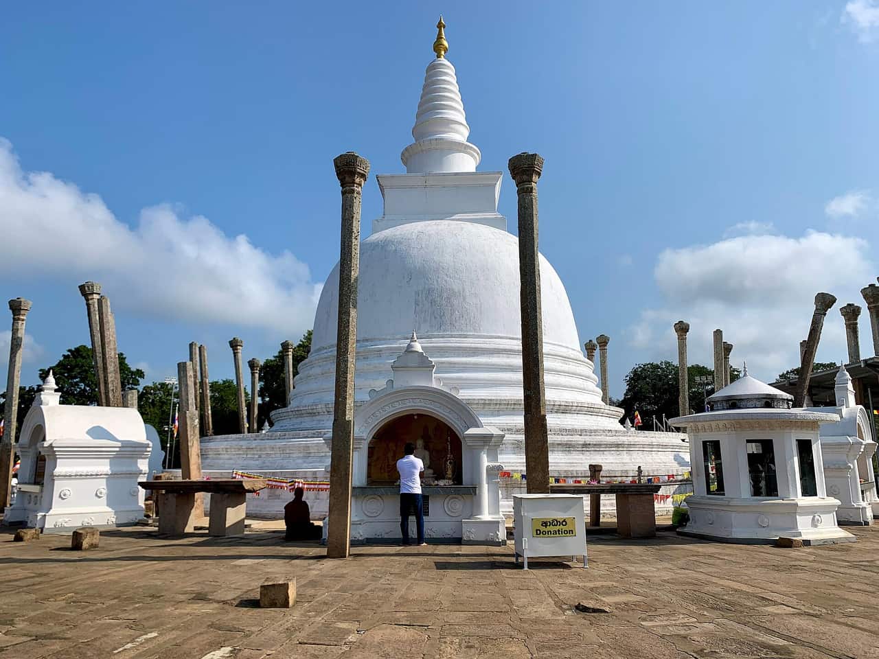 The white Thuparamaya stupa with ancient stone pillars at Anuradhapura