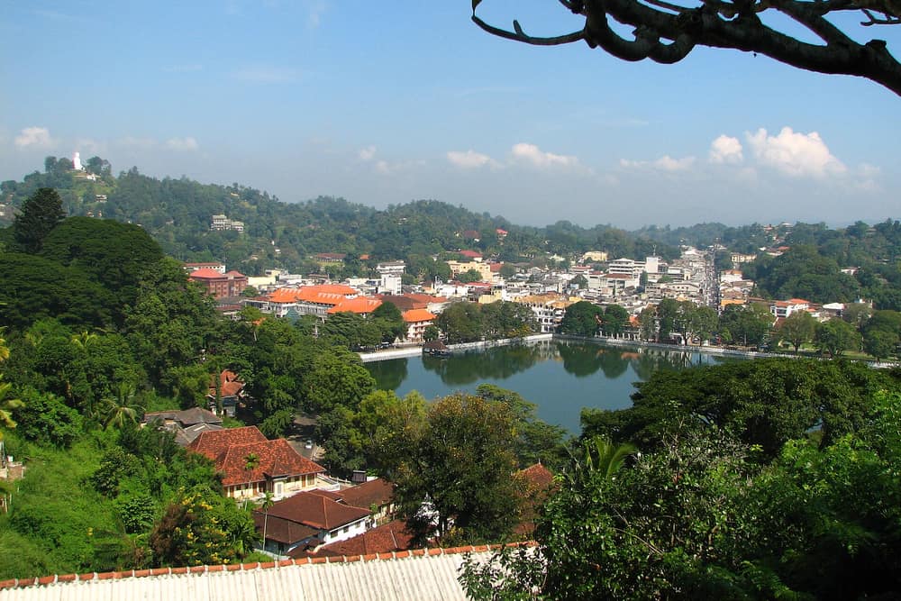 Kandy lake and the city centre seen from a hillside among trees